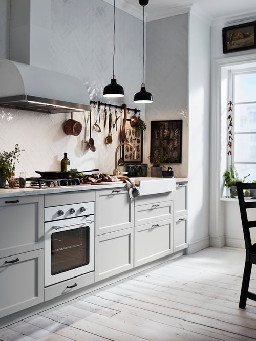 A traditional-styled, off-white kitchen has a white MATTRADITION forced air oven alongside low cabinets with drawers.