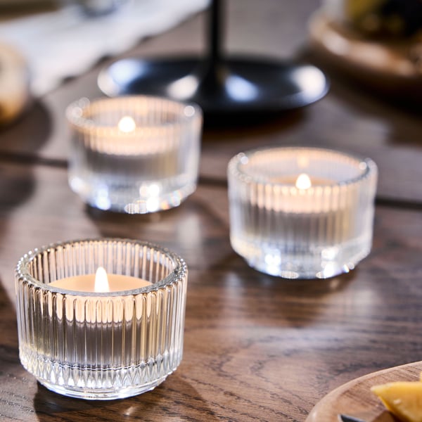 A clear glass FINSMAK tealight holder