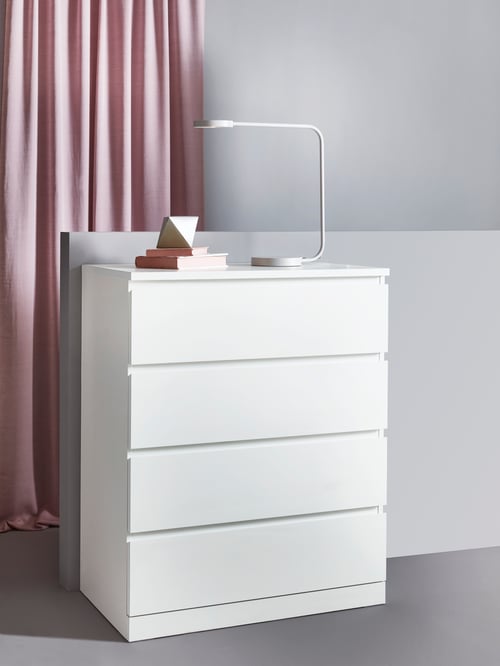 Schlafbereich mit einer MALM Kommode mit 4 Schubladen, HILJA Gardinenschals und einer KAXLIDEN LED-Arbeitsleuchte.