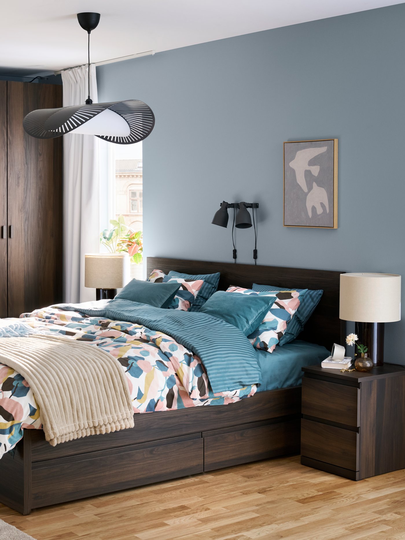 Ein Schlafzimmer mit dunkelbraunen STORKLINTA Schlafzimmermöbeln ist zu sehen.
