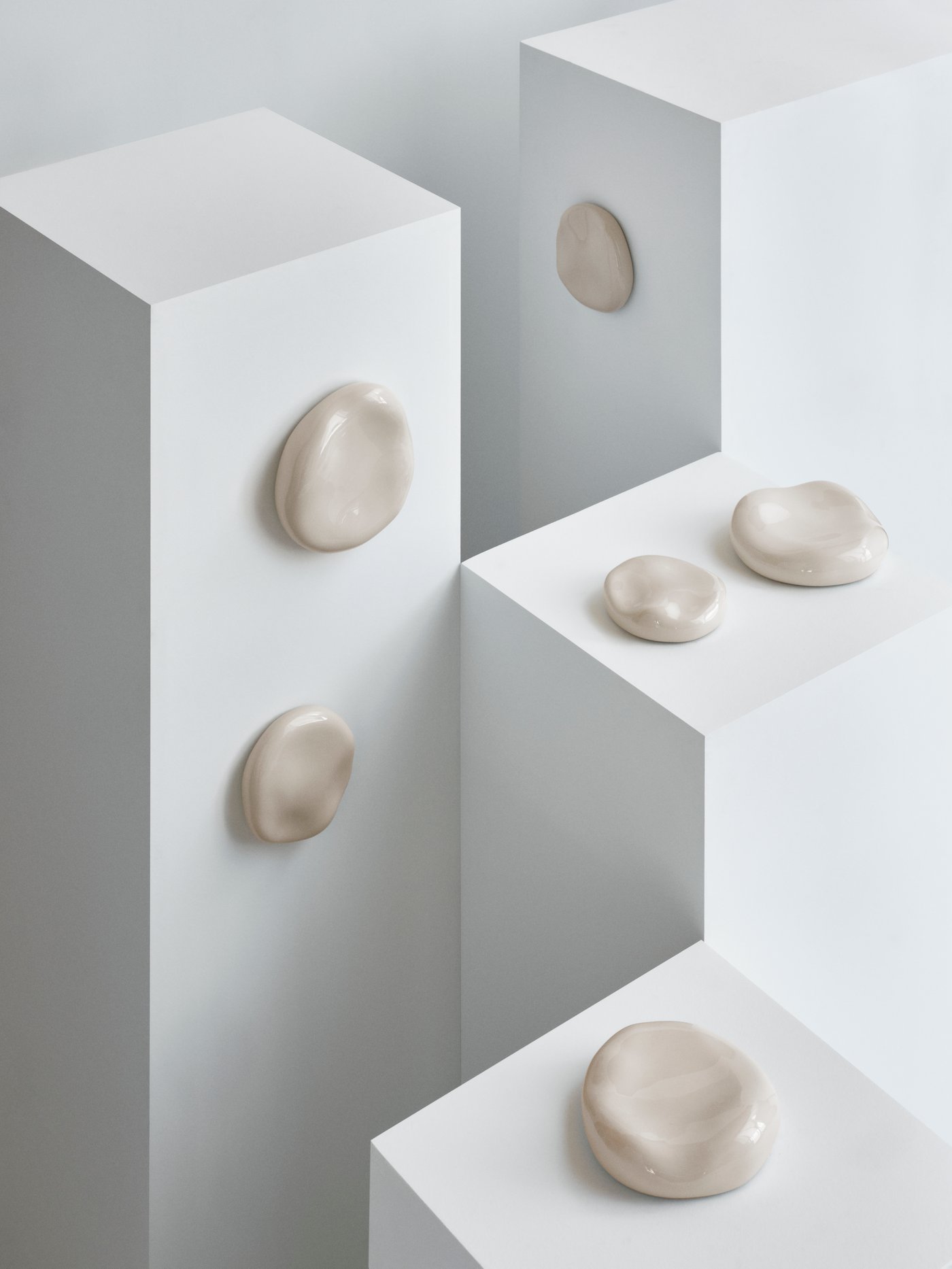 Six small stone-like TRÄDGRÄNSEN wall decorations are mounted on the sides and top of four white boxes.