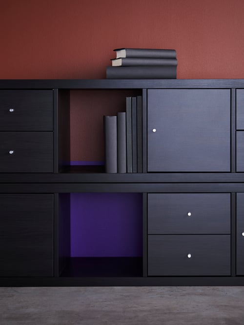 Workspace with two shelving units, stacked on top of each other, with inserts with doors and two drawers, books, and agendas.