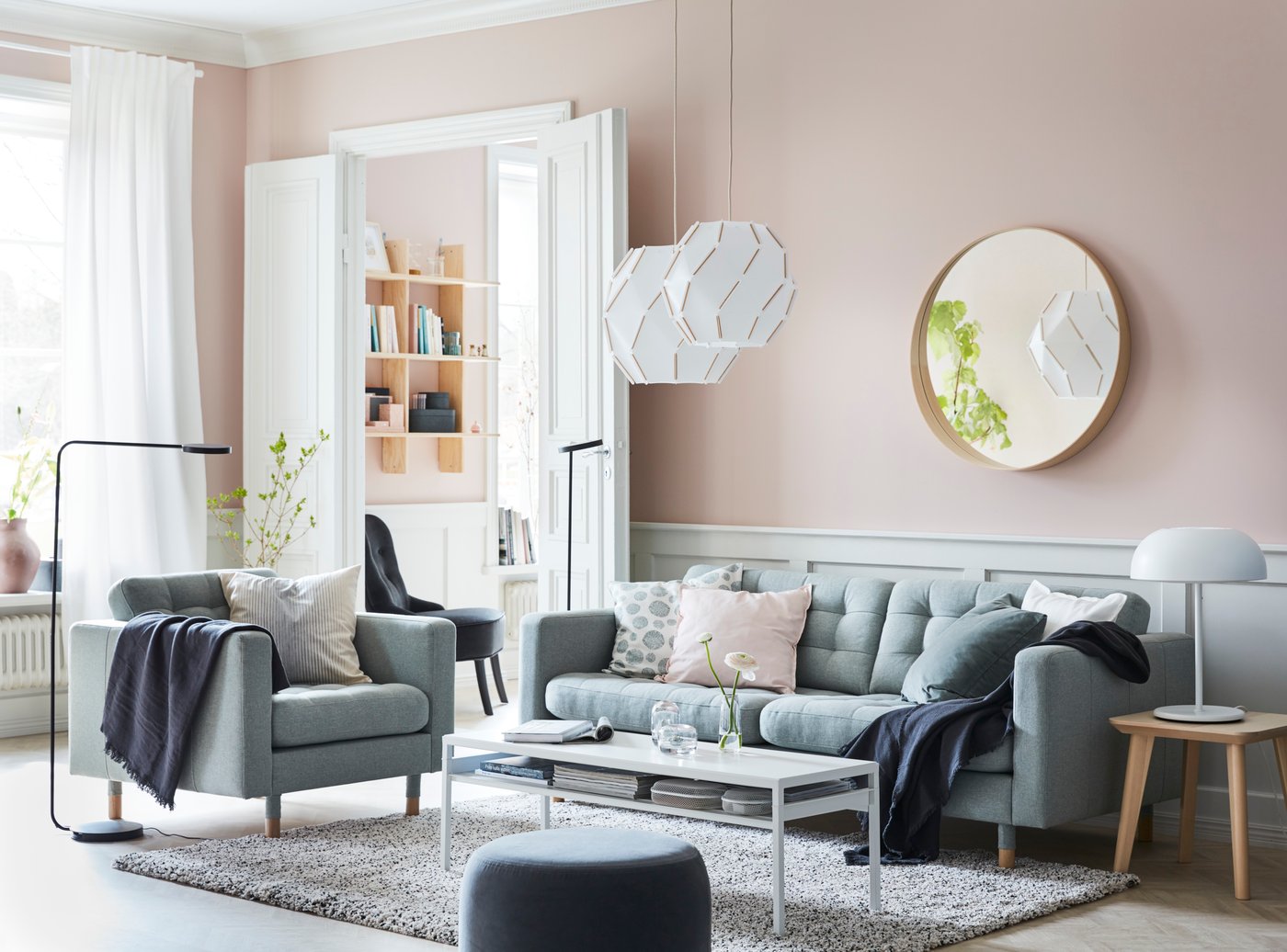 LANDSKRONA light green sofa, SJÖPENNA pendant lamps and black YPPERLIG standing lamps in a pink walled living room.