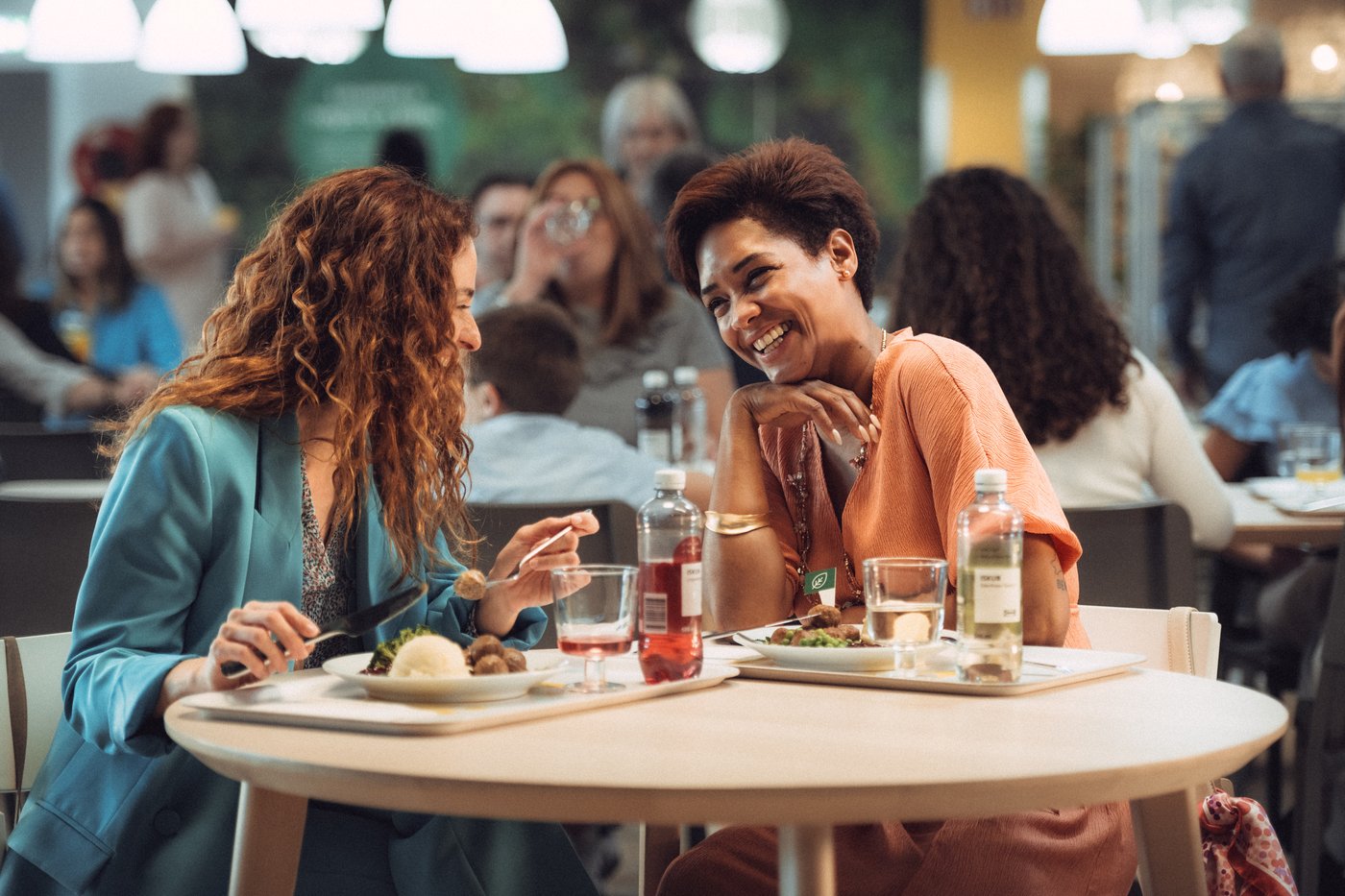 Two people are eating in the IKEA Swedish restaurant and enjoying a dish with meatballs.