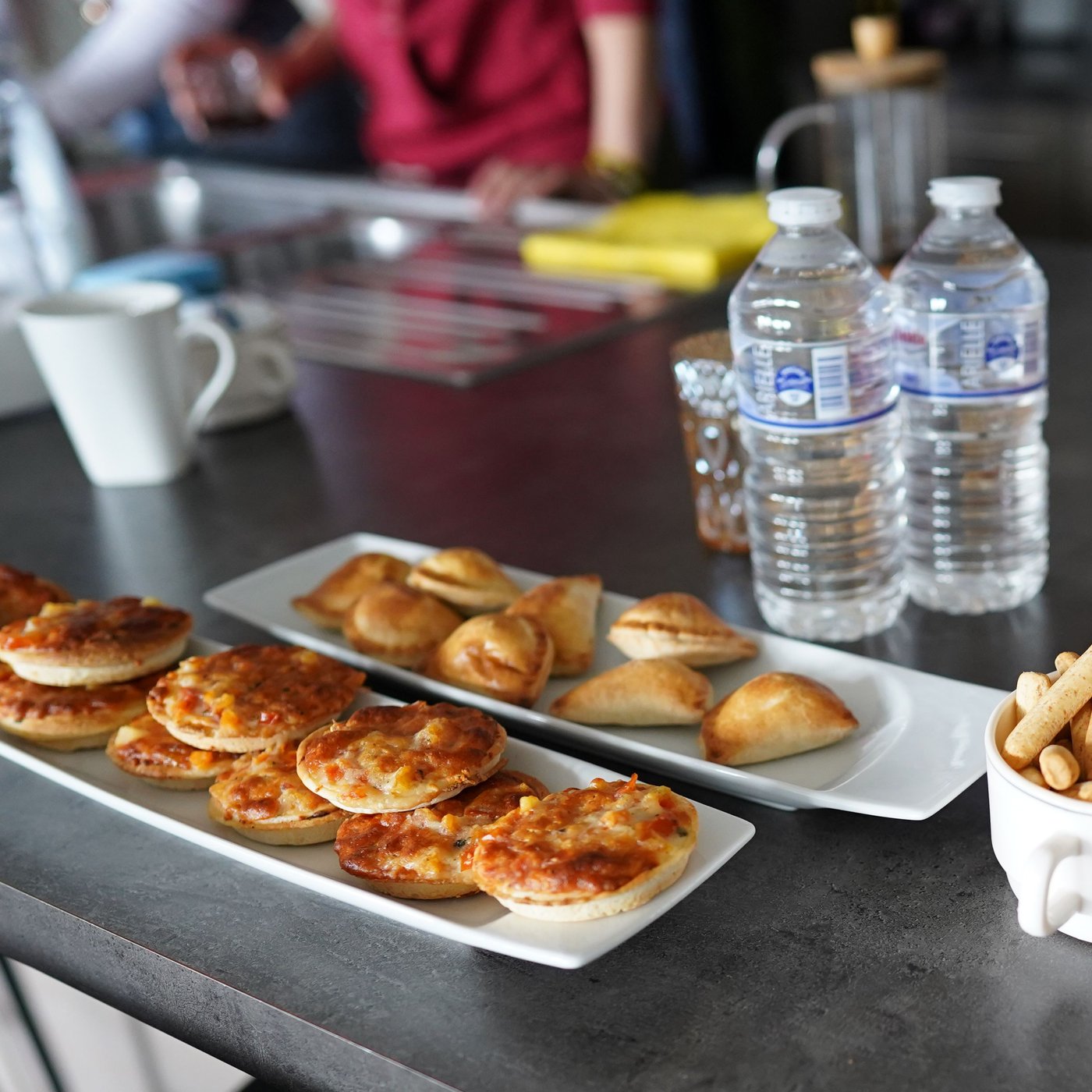 An image of cooies and bottles of water on a table in the kitchen. 