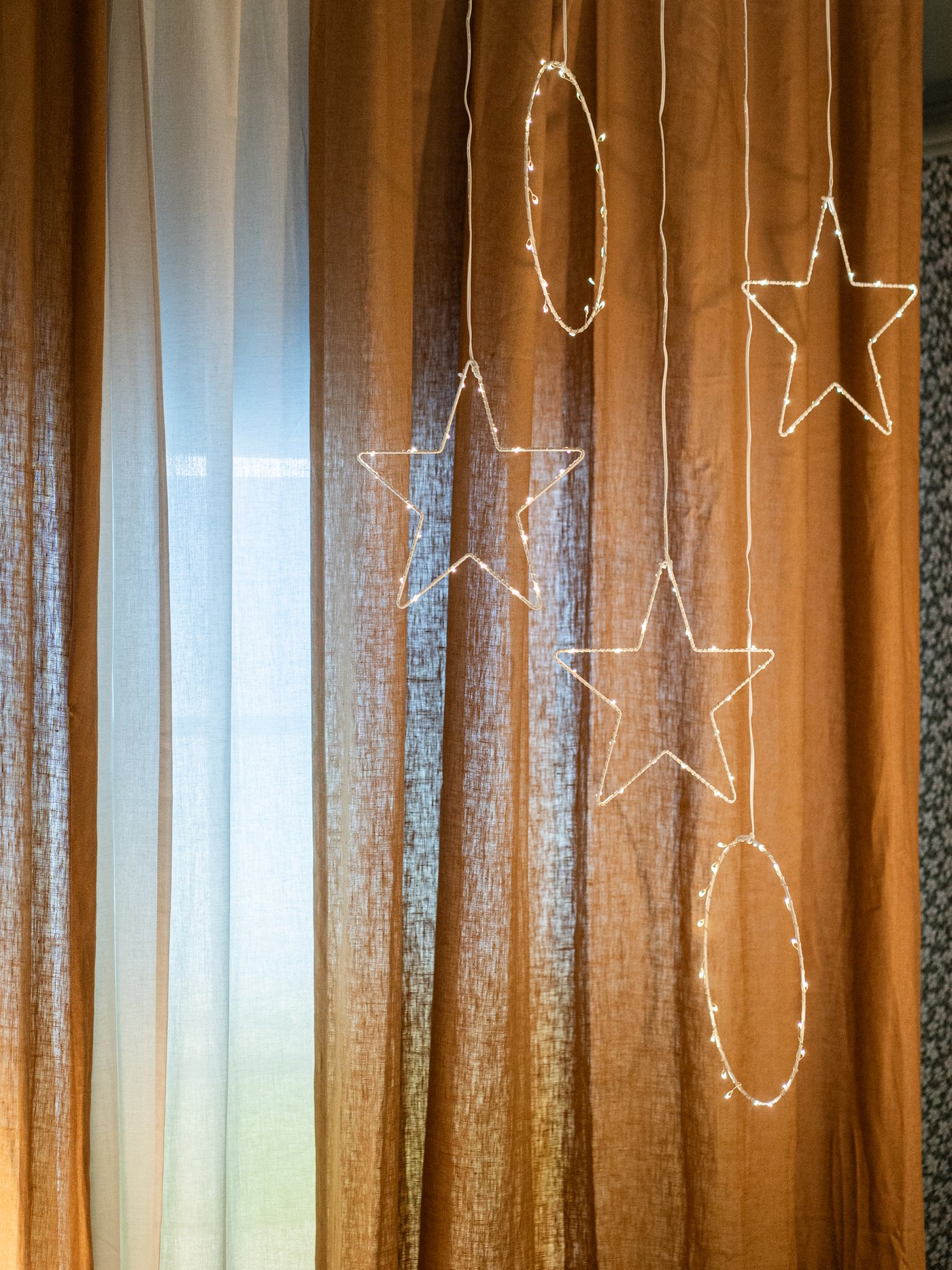 STRÅLA lys hengende foran vinduet.