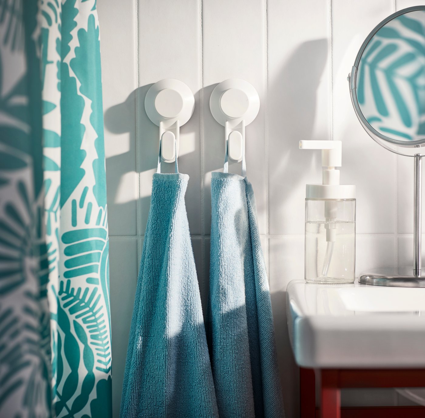 Badeværelse med to kroge, der er klistret på fliser