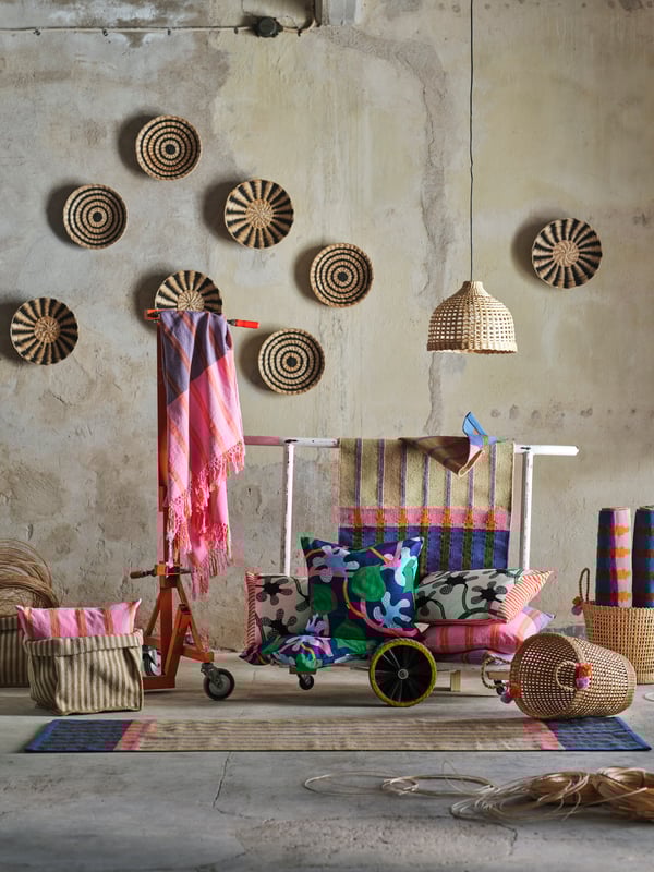 La collection MÄVINN est présentée dans un espace d'aspect industriel. Les fibres naturelles se mêlent aux textiles roses, verts et bleus.