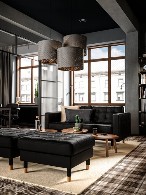Modern workspace with a standard black two-seat sofa with high-resilience seat cushions behind an oval coffee table.