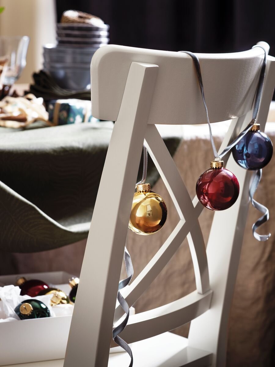 Boles de Nadal sobre una cadira de menjador blanca