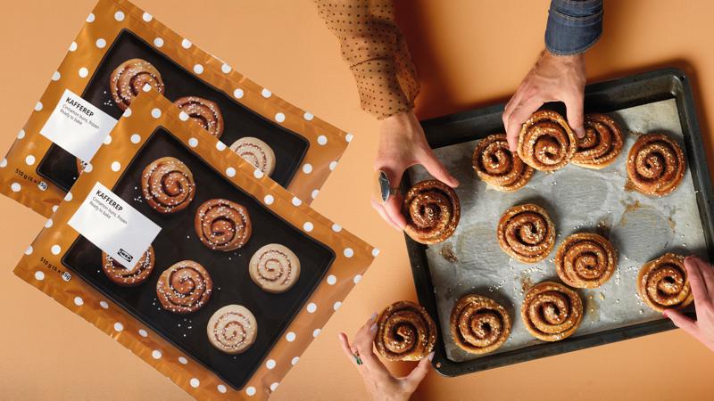 Zwei KAFFEREP Zimtschnecken Packungen und gebackene Zimtschnecken auf einem Blech präsentiert.