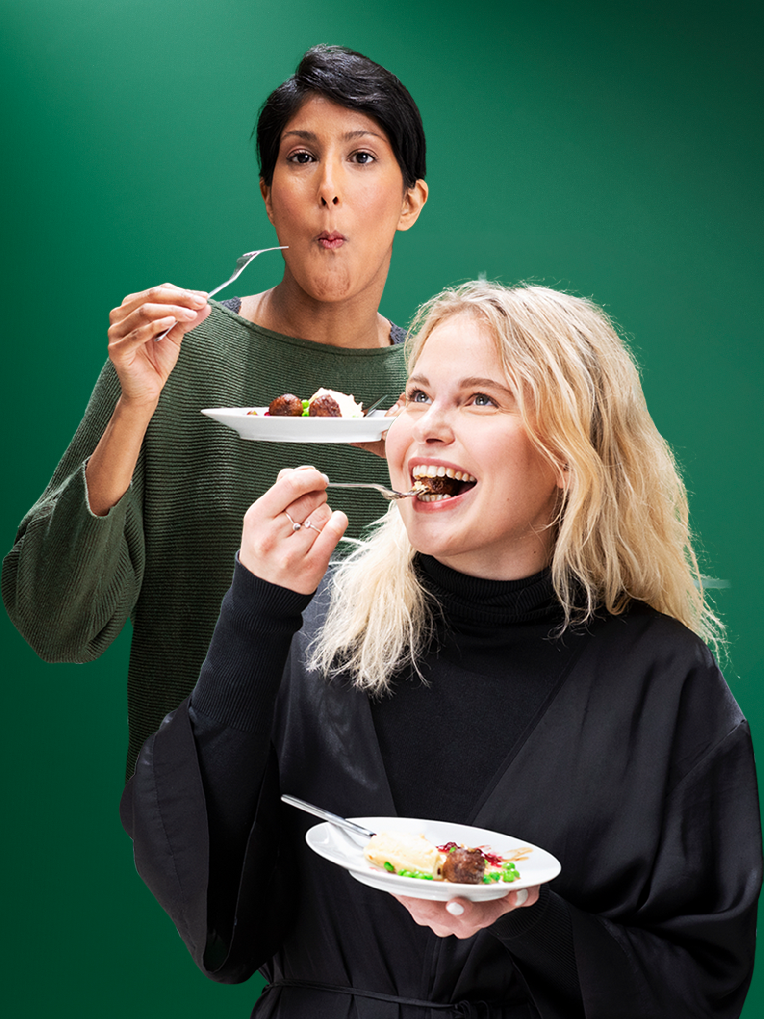 Two people holding white plates enjoy a prepared dish against a green background.