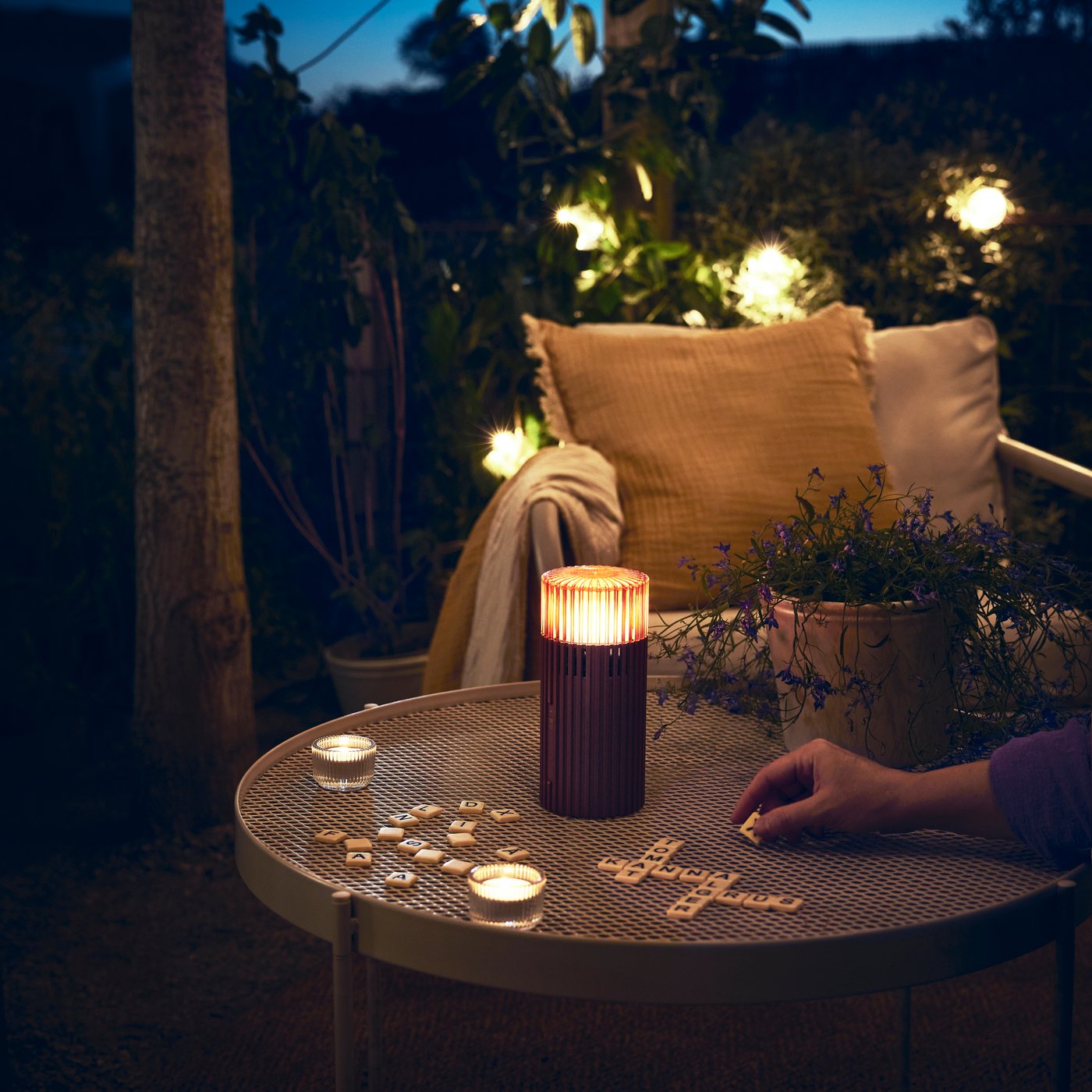 A brown-red STUGBY portable Bluetooth® speaker outside