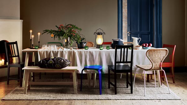 La salle à manger est joliment décorée dans l'esprit de Noël, avec de nombreuses chaises différentes et une banquette.