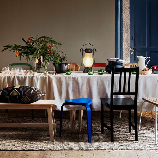 Der Essbereich ist schön und weihnachtlich gedeckt, mit vielen verschiedenen Stühlen und einer Sitzbank.