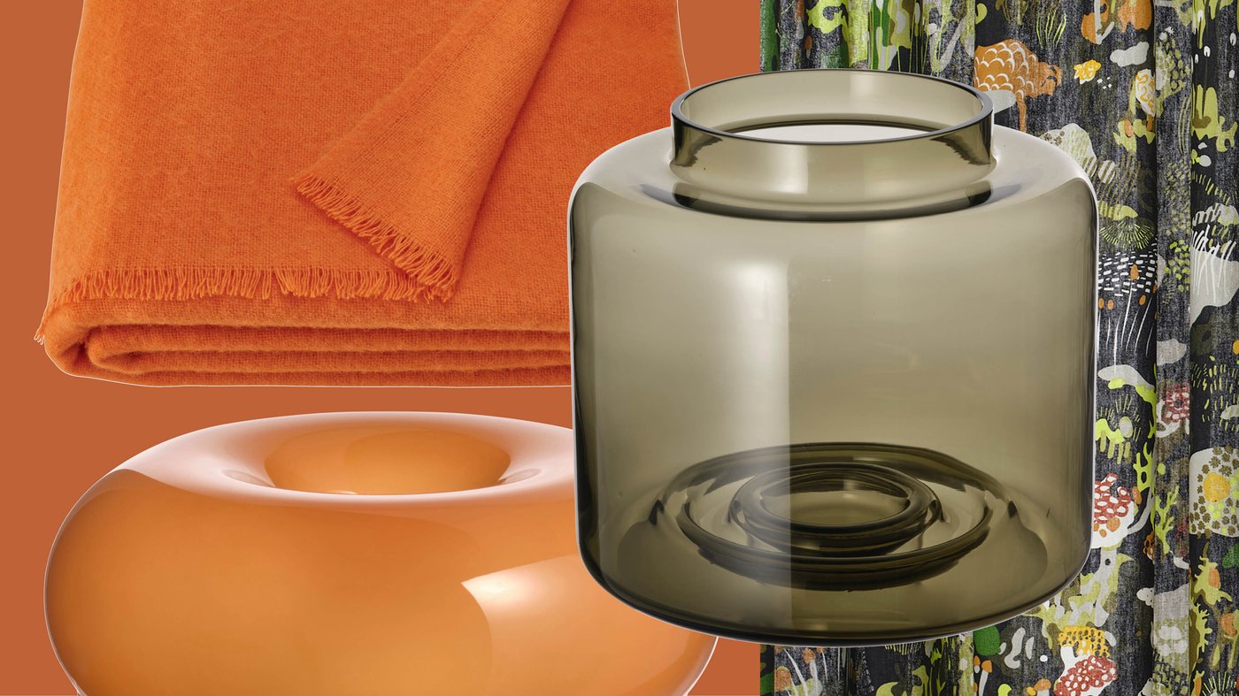 A mix of colorful décor items, including an orange throw, a sculptural bowl and a smoky glass vase, reflects the retro aesthetic often seen in IKEA collections.