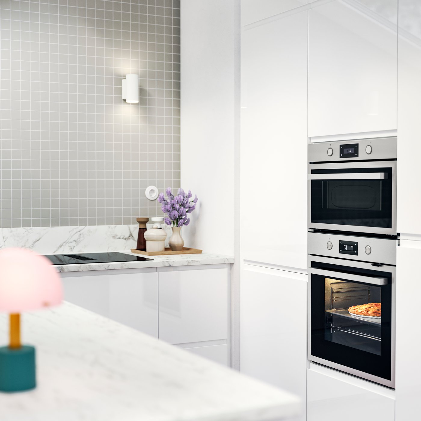VOXTORP kitchen with white high-gloss fronts, a pizza in the oven, and a tiled backsplash with a soft grey tone.