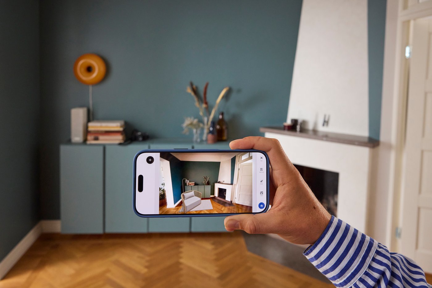 Wyciągnięta dłoń z telefonem z otwartą aplikacją IKEA Kreativ