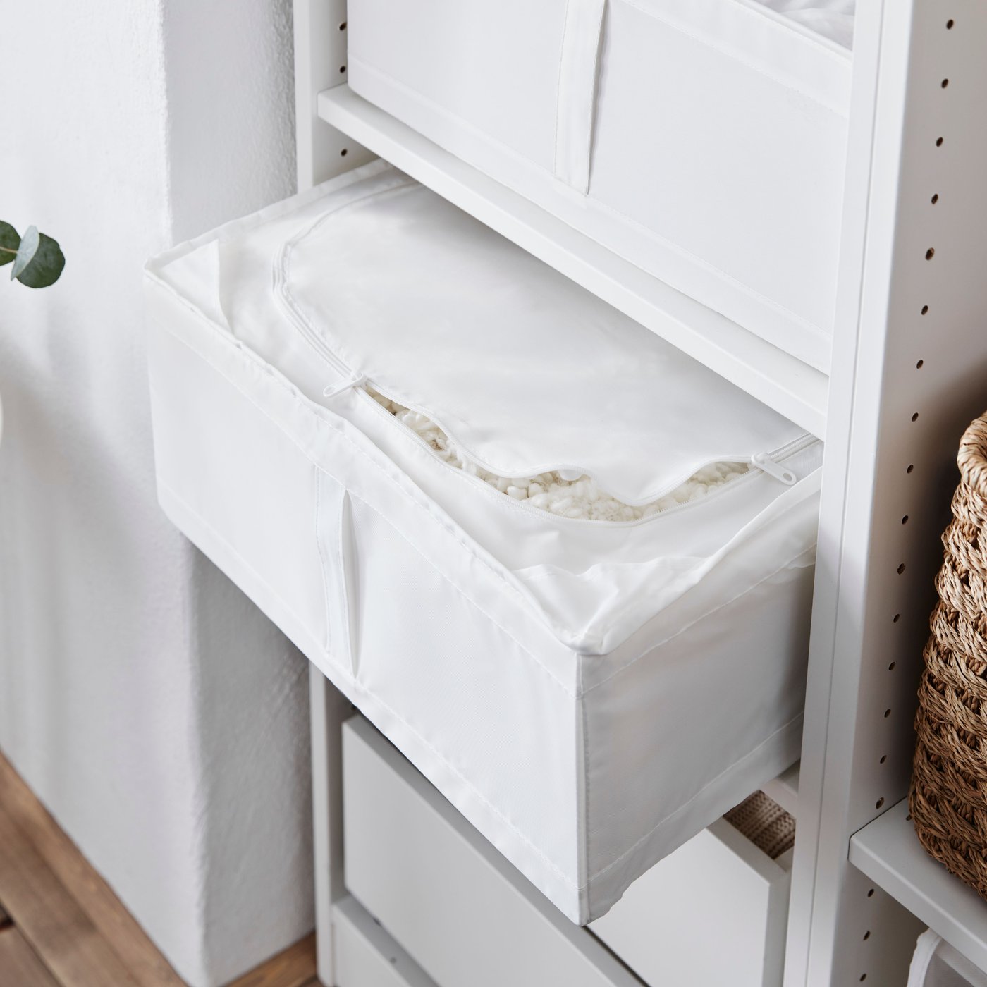 Un contenitore bianco SKUBB all'interno di un armadio PAX