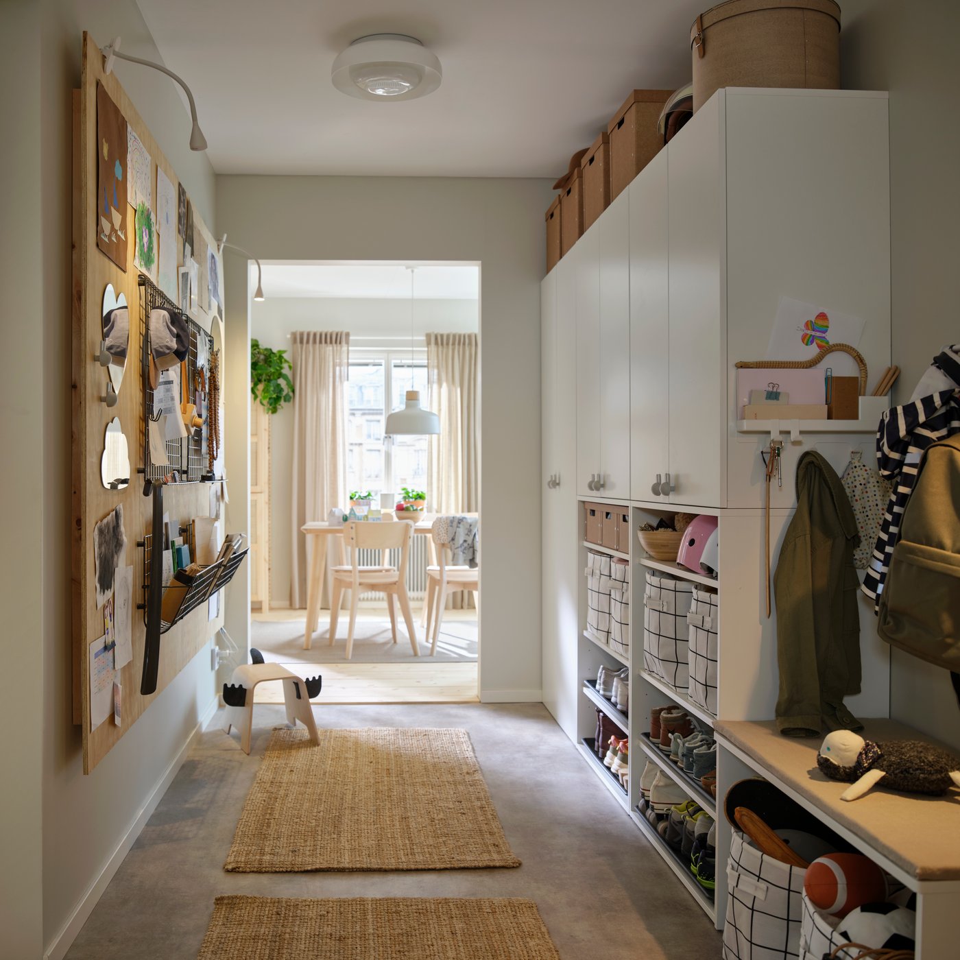 A hallway with LASTARE wardrobe combinations along one wall, shown with closed cabinets, open shelving and storage baskets.