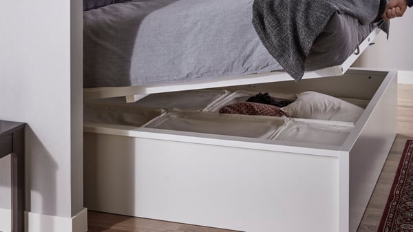 A bed frame with slide out storage holding fabric containers