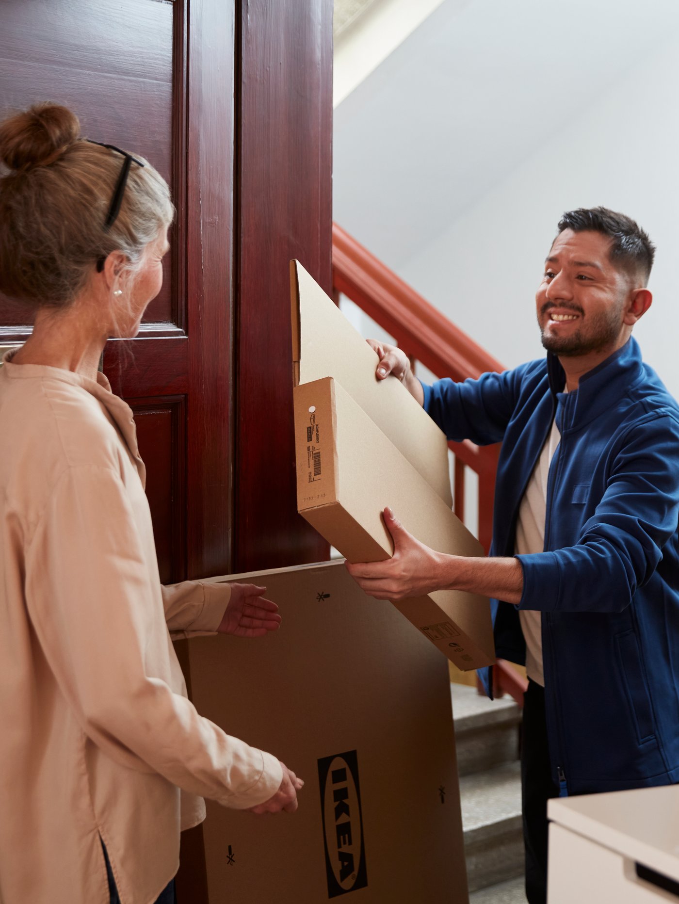 An IKEA co-worker delivering a flat pack box to a customer.