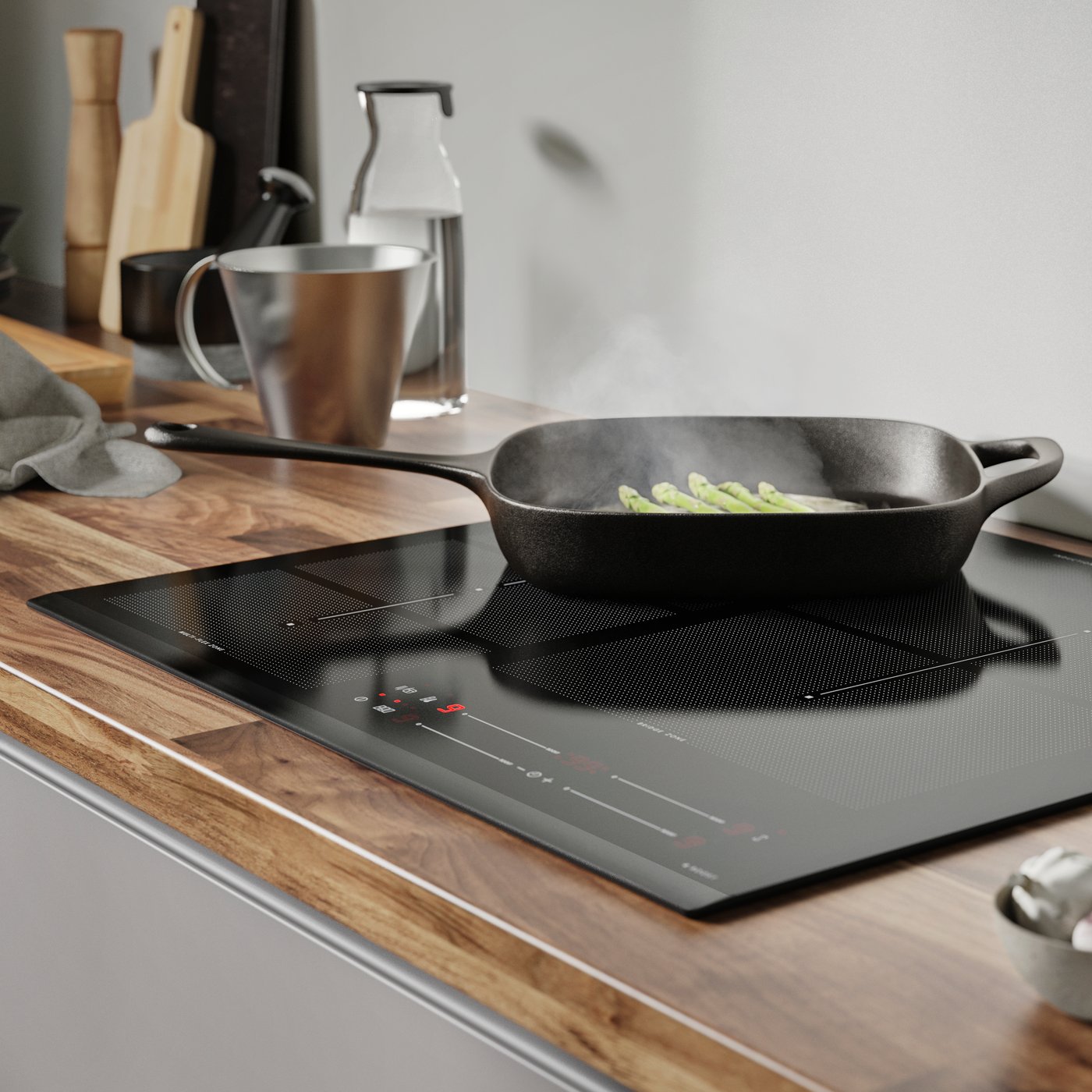 I et køkken ses en sort HÖGKLASSIG induktionskogeplade med en sort VARDAGEN pande ovenpå.