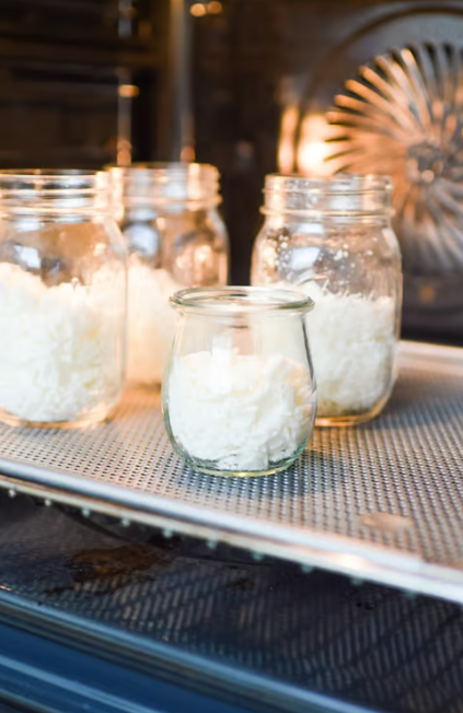 Sojawachs in Gläsern, die in einen Ofen gestellt werden