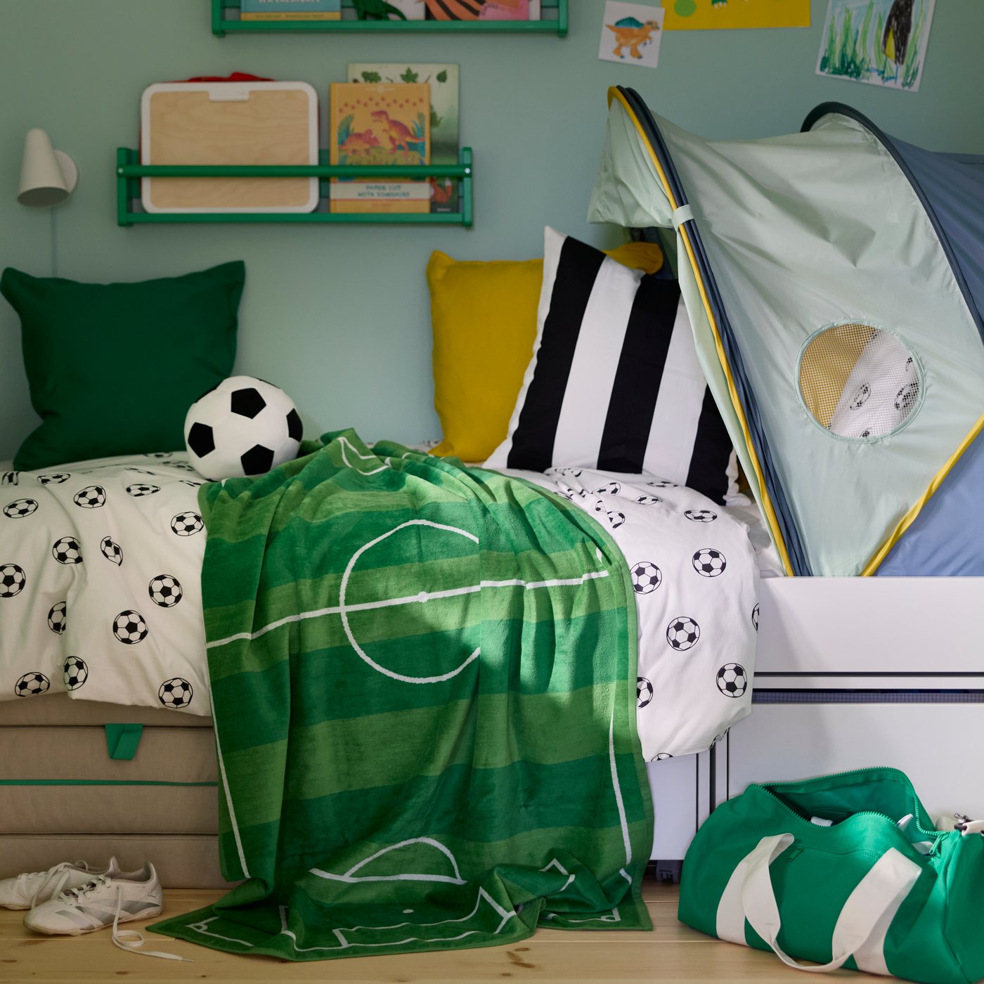 SPORTSLIG bath sheet in green with white football pitch pattern draped over a bed in a children’s room.