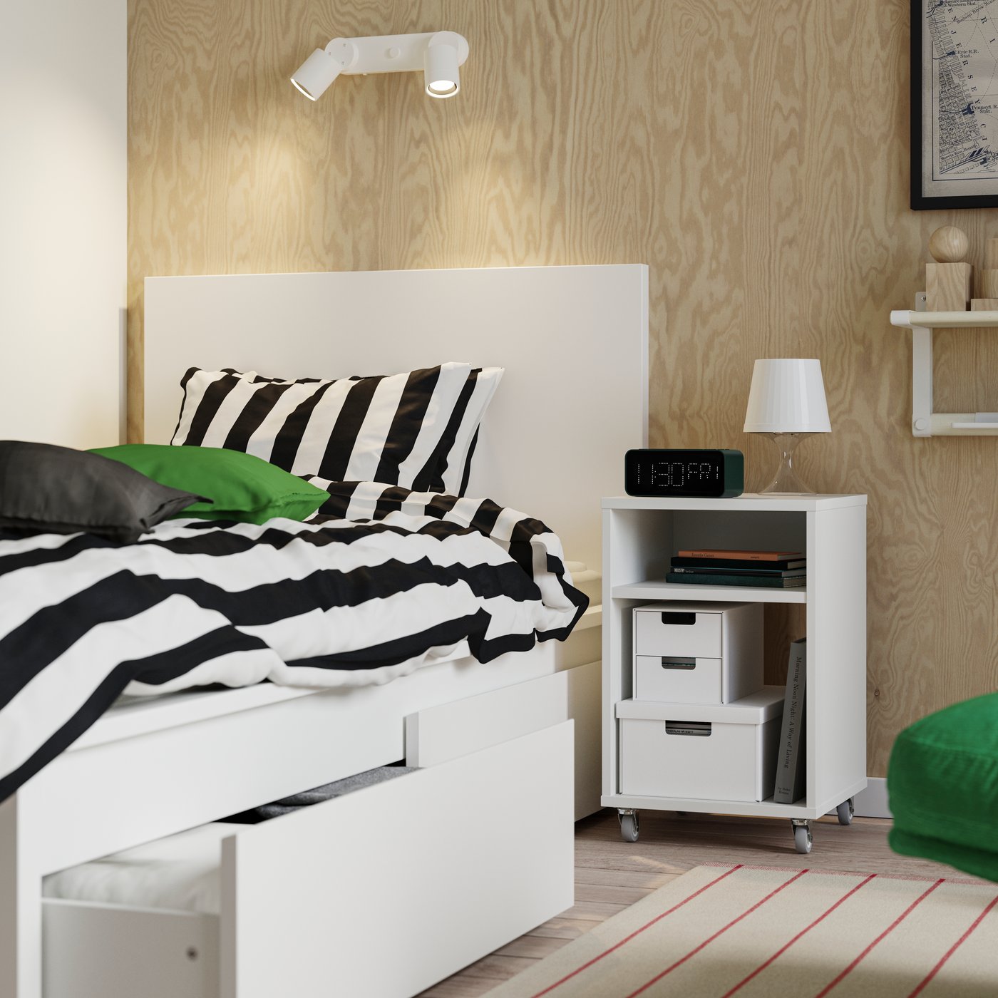 En hvid MALM sengeramme med to opbevaringsbokse, den ene åbnet med tekstiler. Ovenpå ses et SLÅNHÖSTMAL dynebetræk.