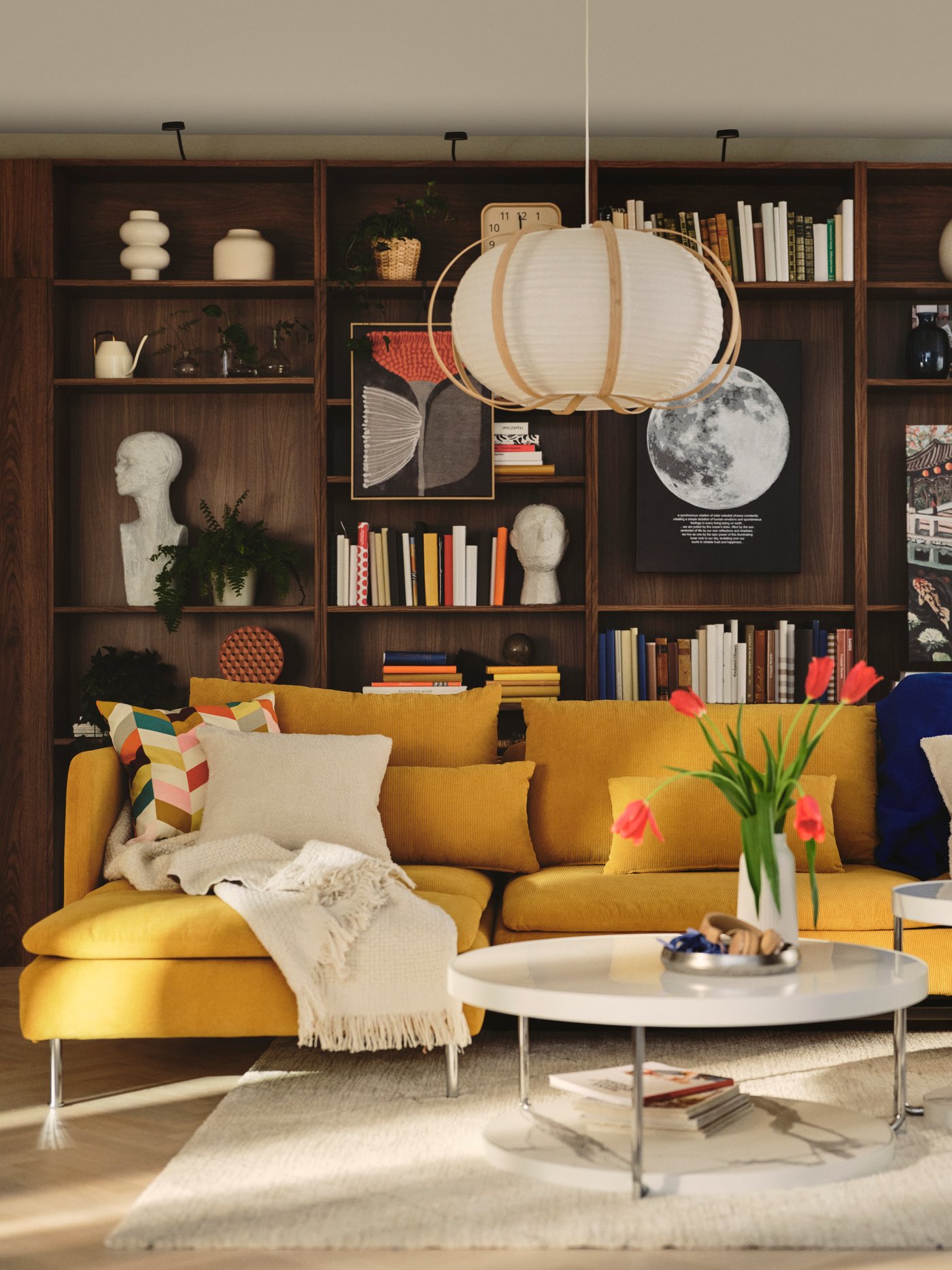 A living room features a dark yellow SÖDERHAMN 4-seat sofa-bed with chaise longue, beside a coffee table and vibrant décor.