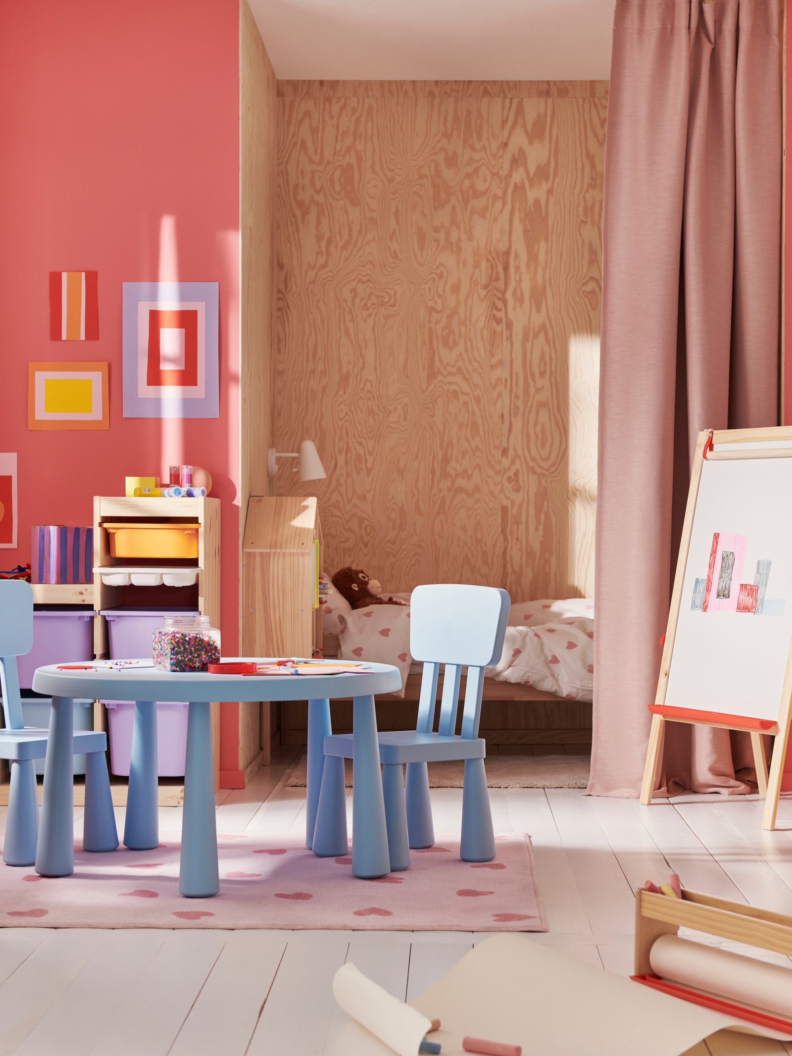 Svetloplavi MAMMUT dečji sto i dve stolice nalaze se u raznobojnoj dečjoj sobi, a ispod njih je roze BARNDRÖM tepih.