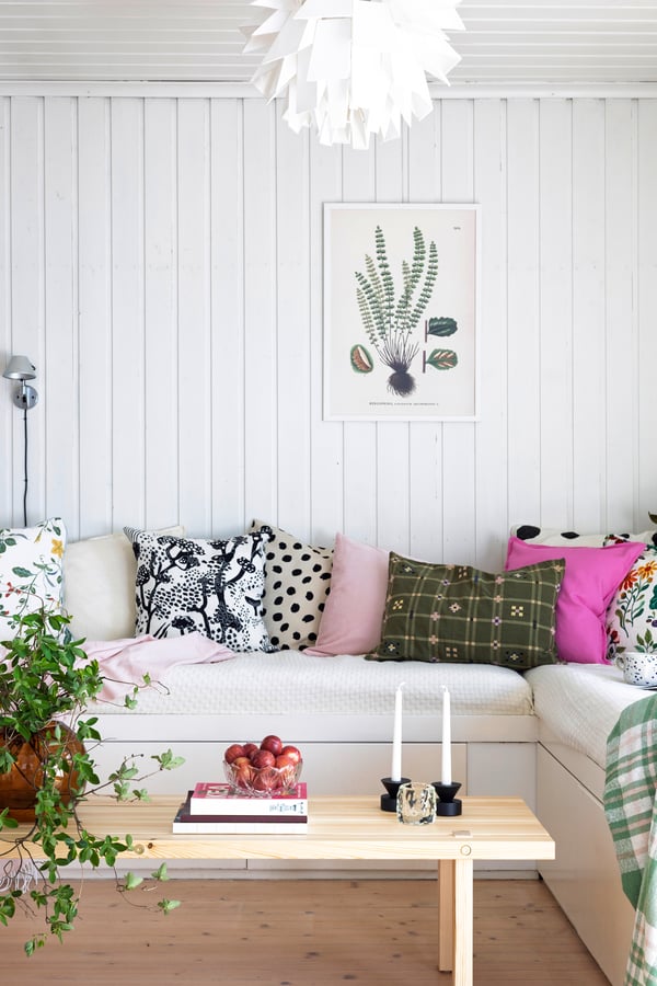 Sofa i stua med puter i ulike farger og mønstre. 