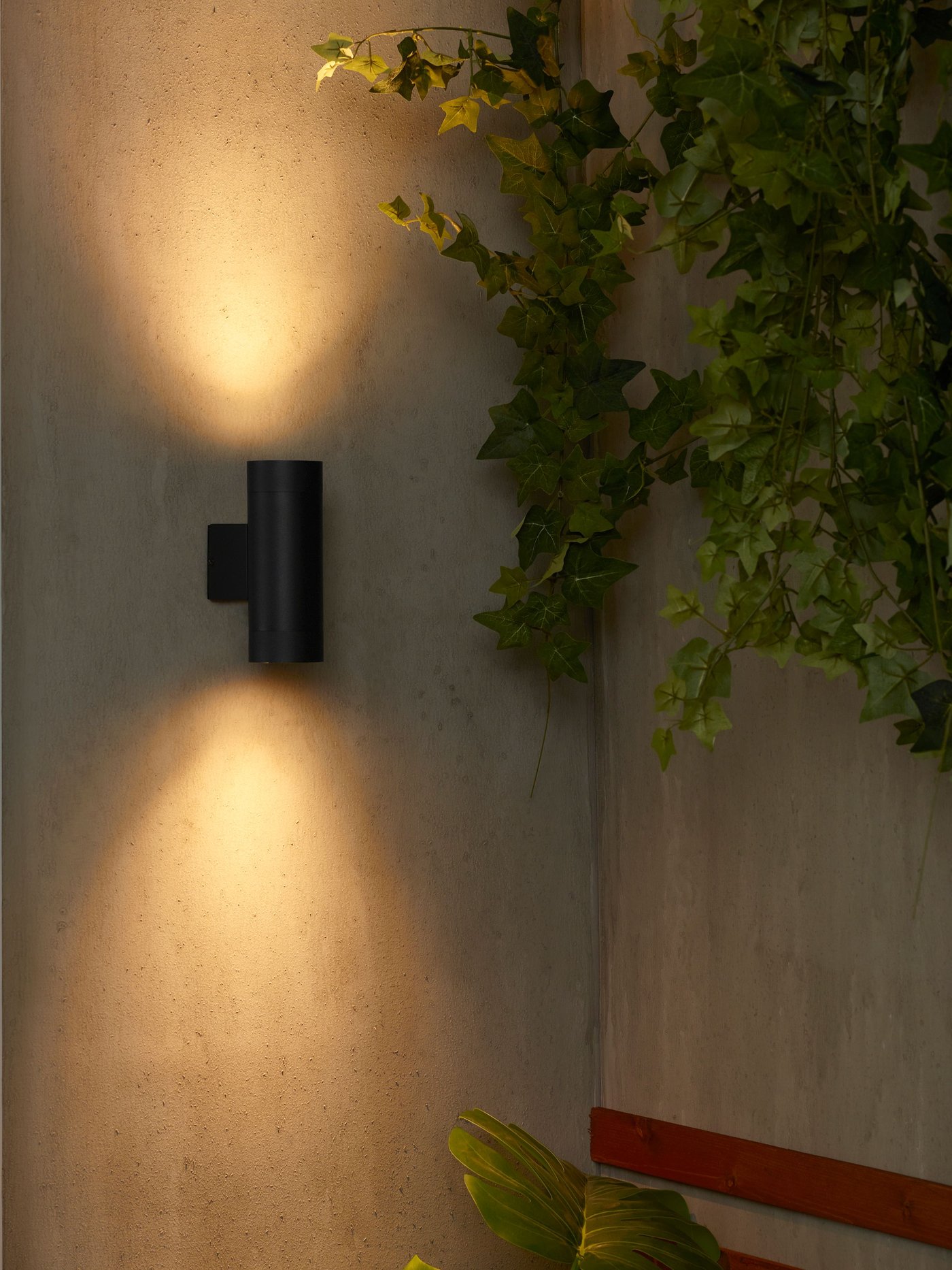 A GRÖNSPRÖT outdoor lighting spot on the wall shining light.