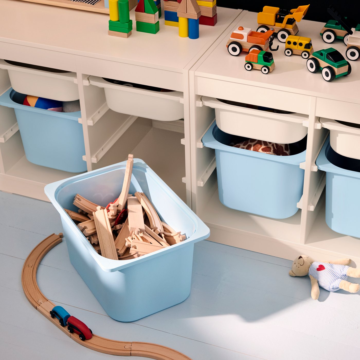TROFAST storage system seen from above, with a light blue storage boxes pulled out to show LILLABO train rail pieces inside.