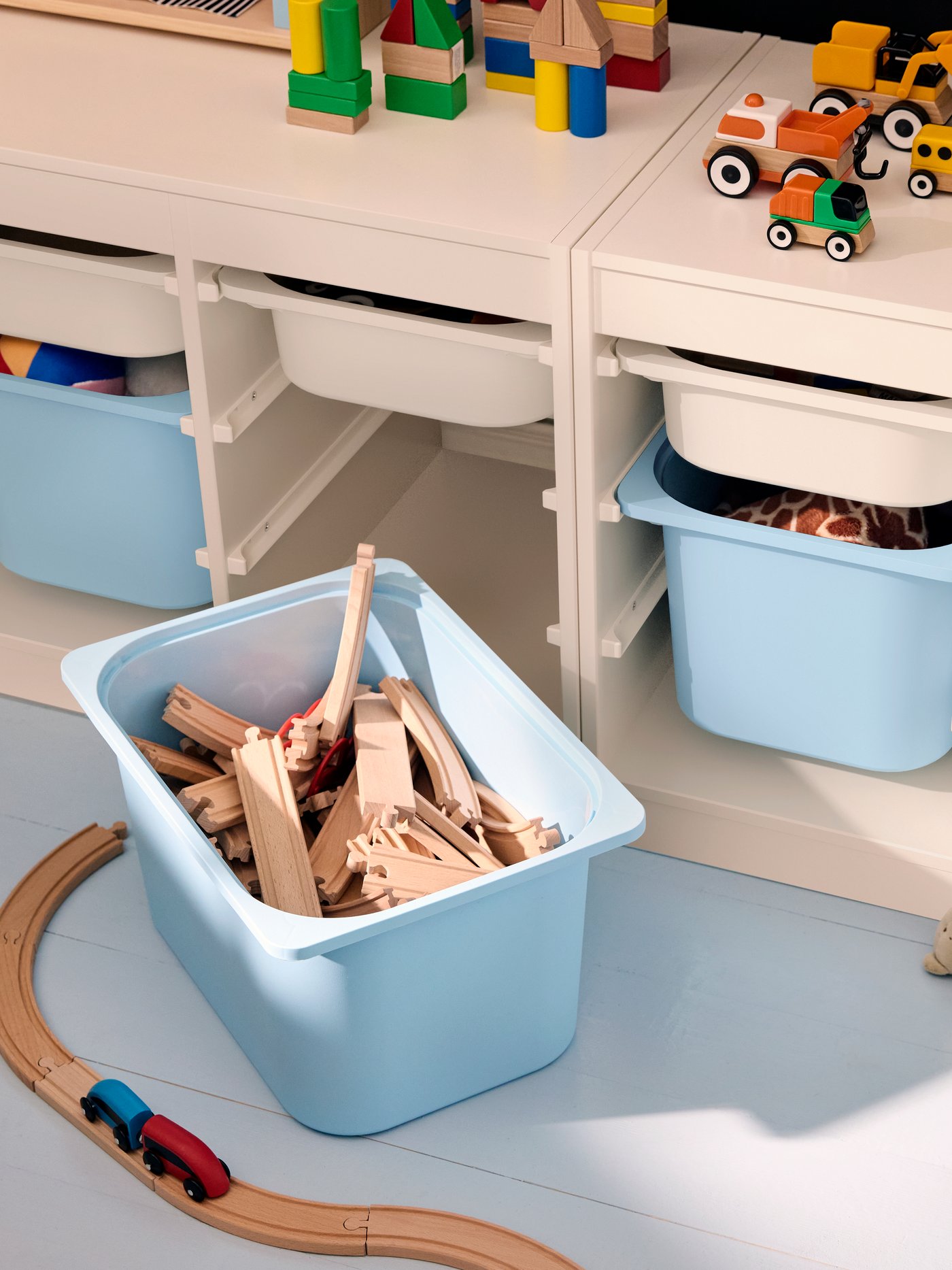 TROFAST storage system seen from above, with a light blue storage boxes pulled out to show LILLABO train rail pieces inside.