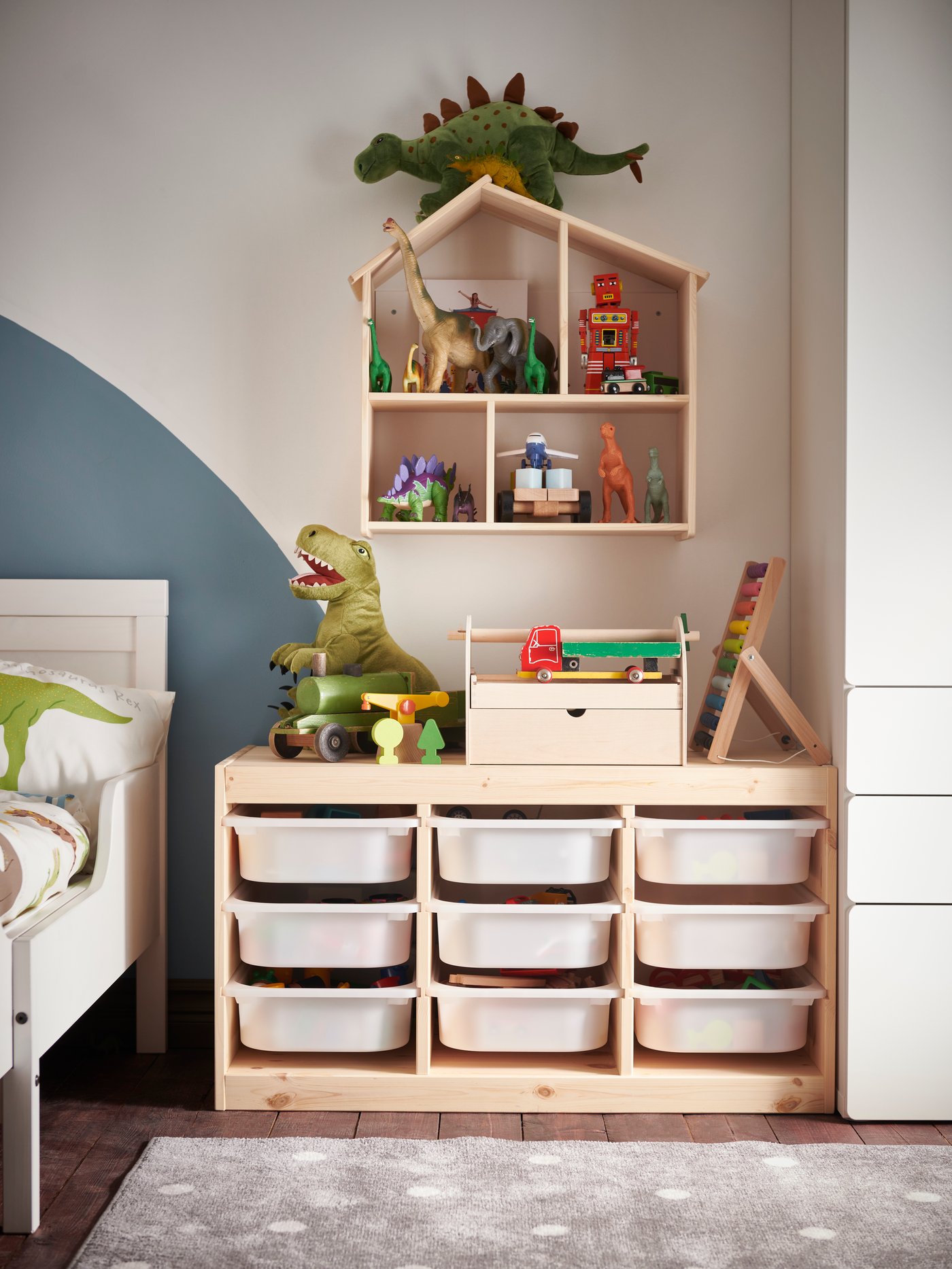 Una repisa de madera LUSTIGT en forma de casa con juguetes en su interior