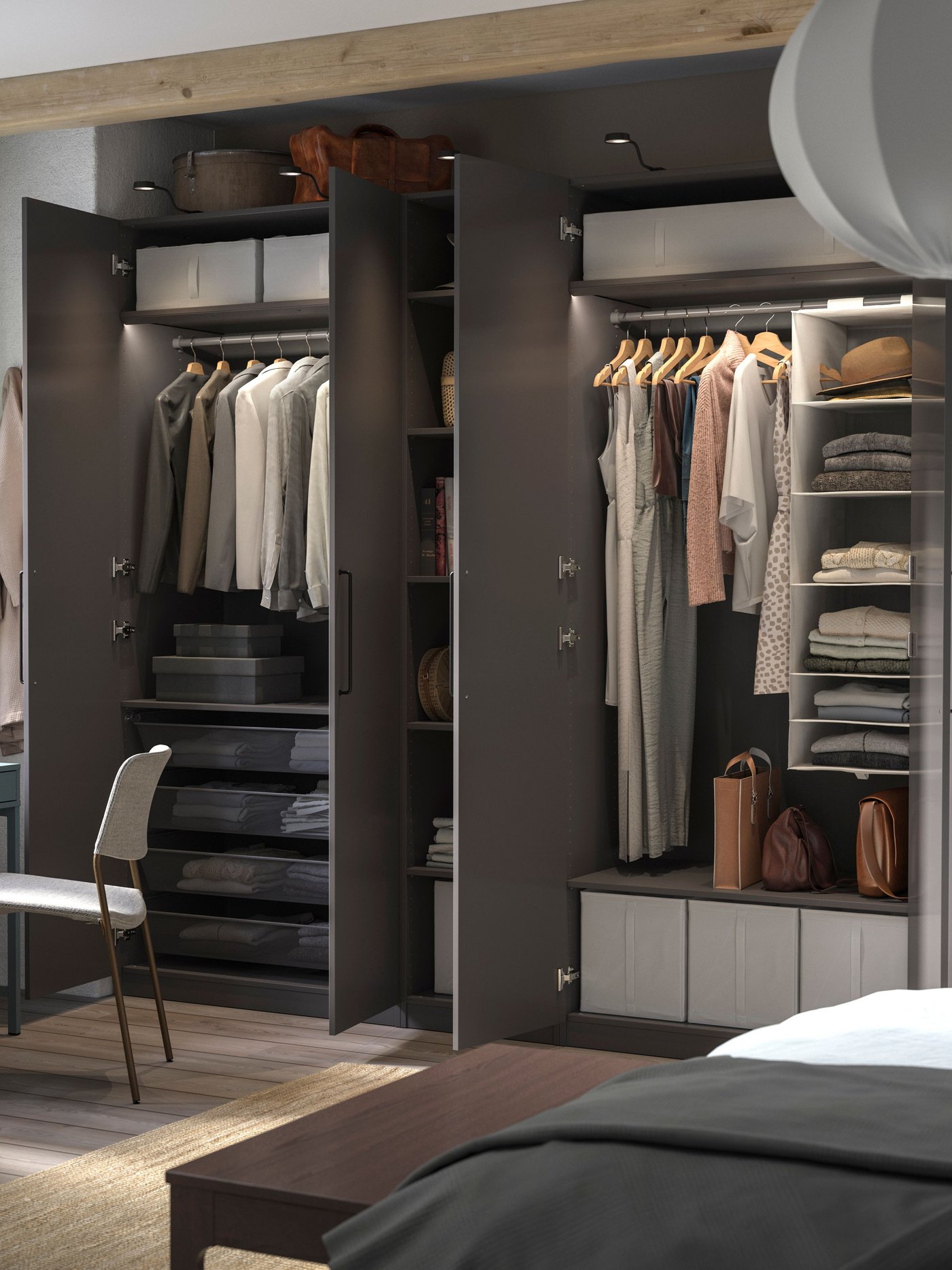 Tmavě šedá šatní skříň PAX plná oblečení s otevřenými dveřmi. Skříň je zevnitř osvětlená, s policemi, tyčemi a výsuvnými drátěnými košmi.