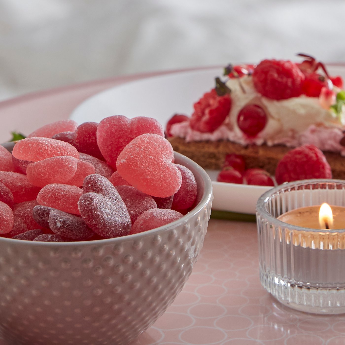 A clear glass FINSMAK tealight holder in the bedroom