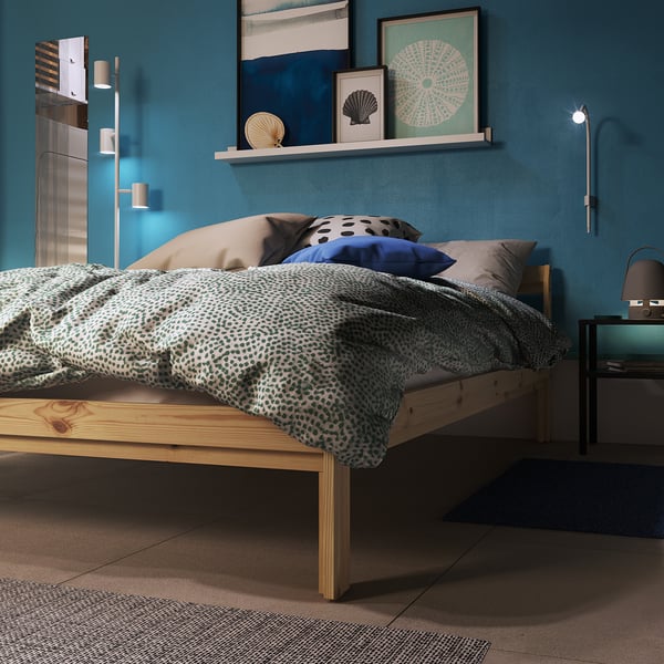 Dormitorio con escritorio ALEX, lámpara y silla giratoria ODGER detrás de la cabecera de una cama FINNSNES.
