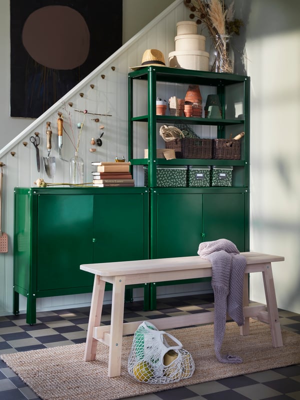 A NORRÅKER bench stands in a hallway in front of two KOLBJÖRN cabinets with a KOLBJÖRN shelving unit on top of one of them.