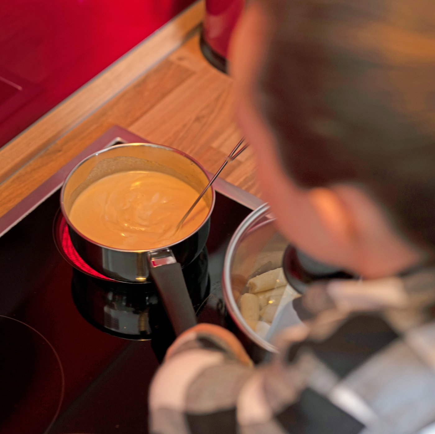 女性がコンロの上の鍋に入ったALLEMANSRÄTTEN/アレマンスレッテン クリームソースをかき混ぜている。