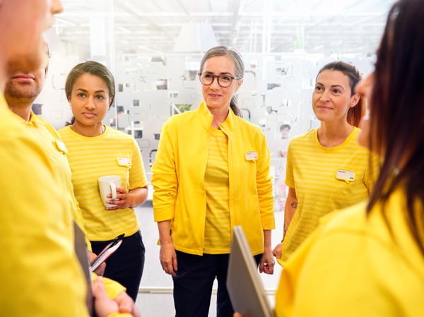A group of IKEA co-worker wearing a yellow IKEA uniform.