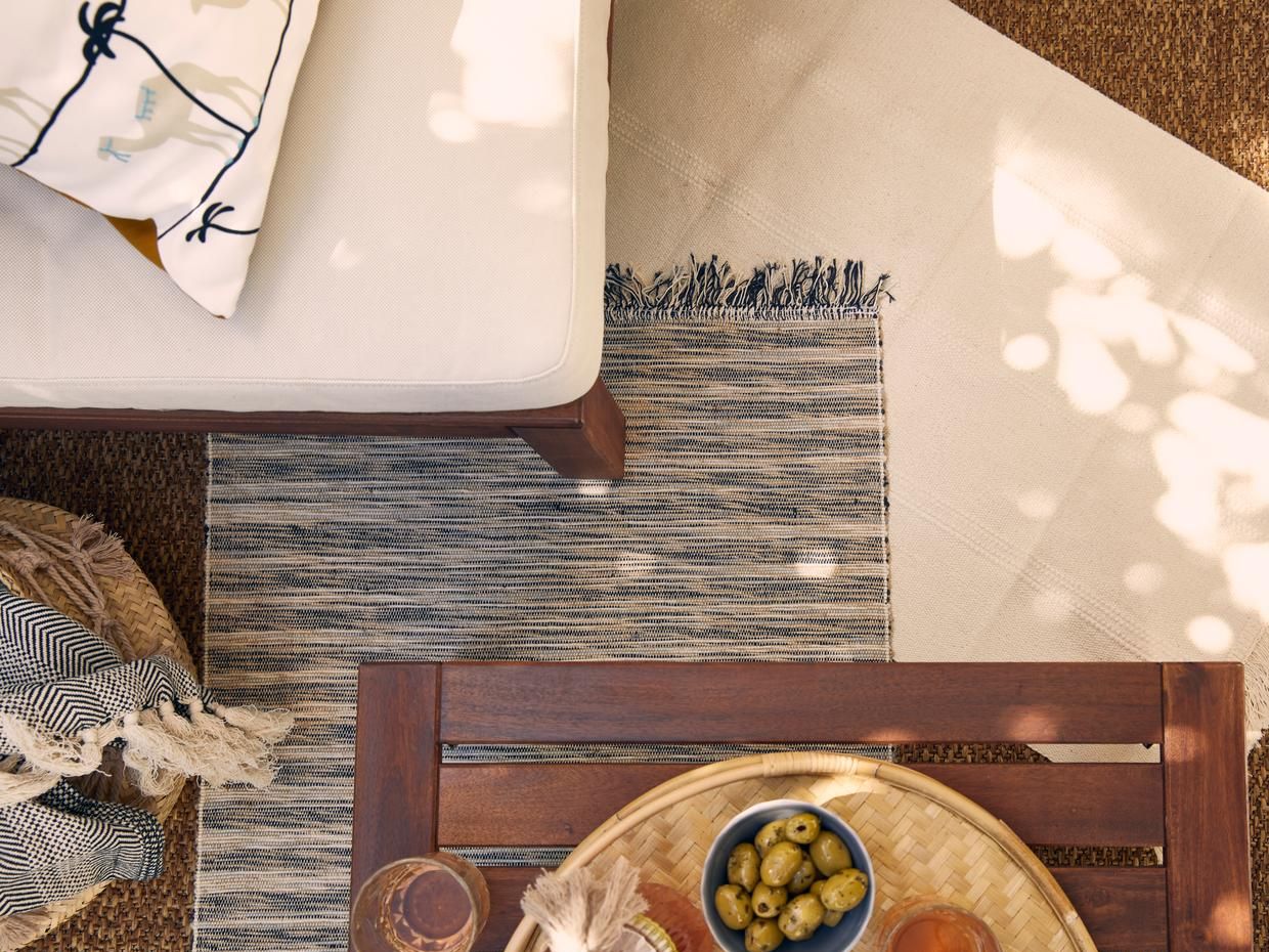 Weisser und melierter Teppich mit Gartenlounge und Apéro