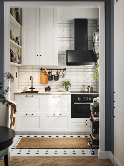 A kitchen with AXSTAD drawer fronts, a wall mounted hood, an inset sink, a microwave combi with forced air and a grey kettle.