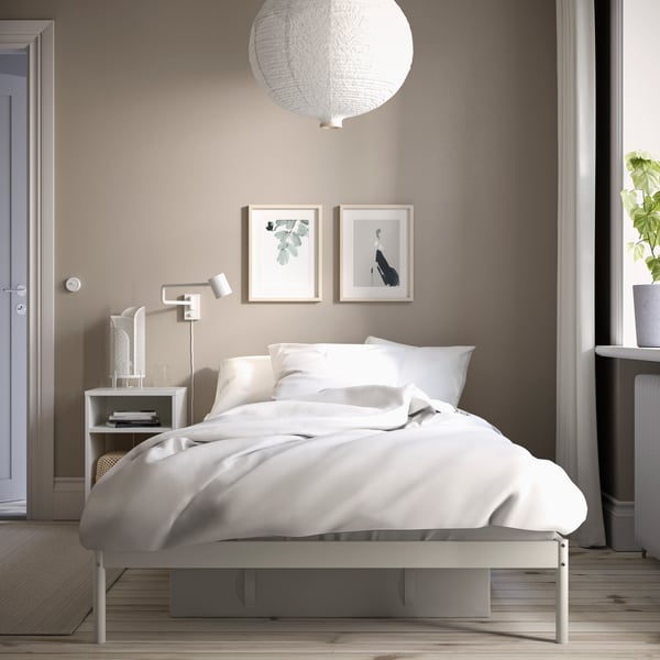 A white VEVELSTAD bed frame