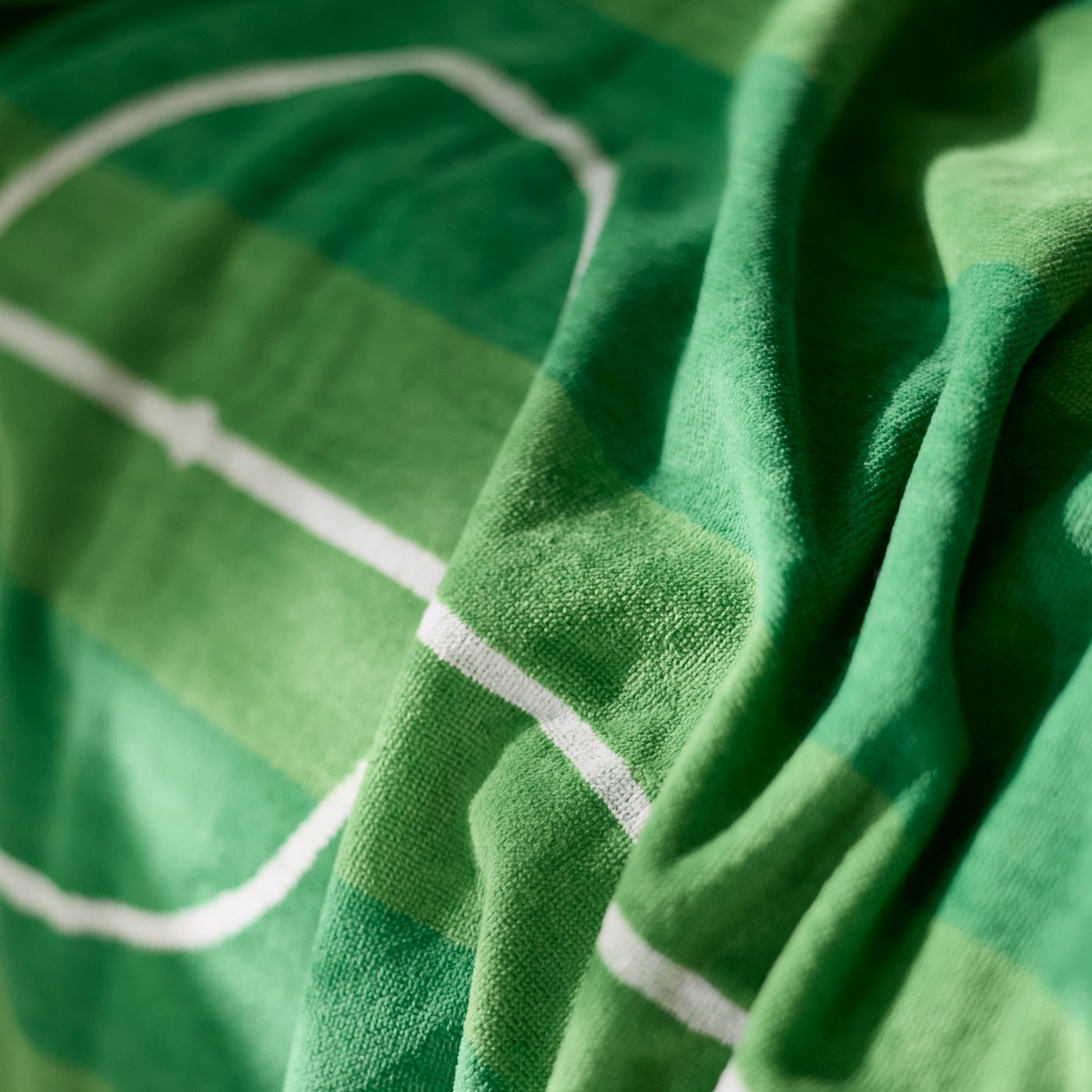 SPORTSLIG bath sheet in green with white football pitch pattern spread out showing its design.