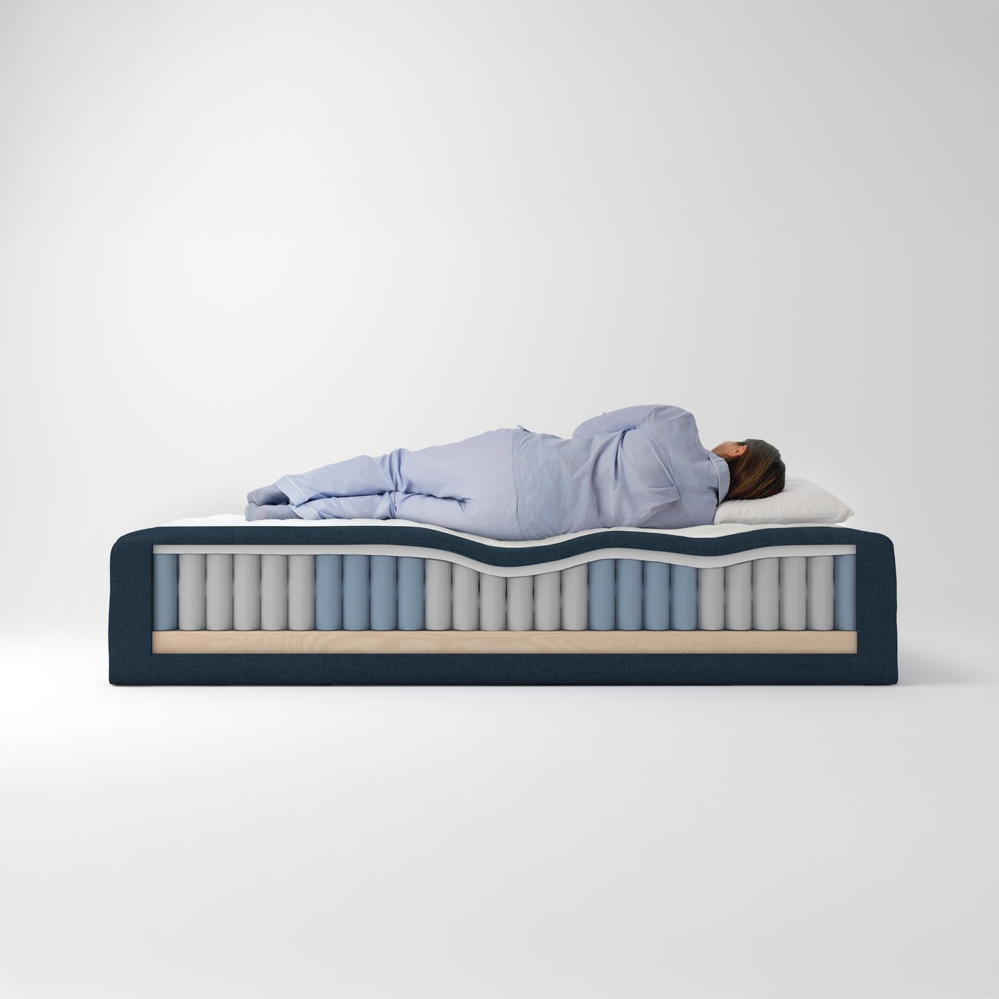 A person lies sleeping on a FÄGERÅSEN pocket spring core which has had part of its wooden base cut away on one side.