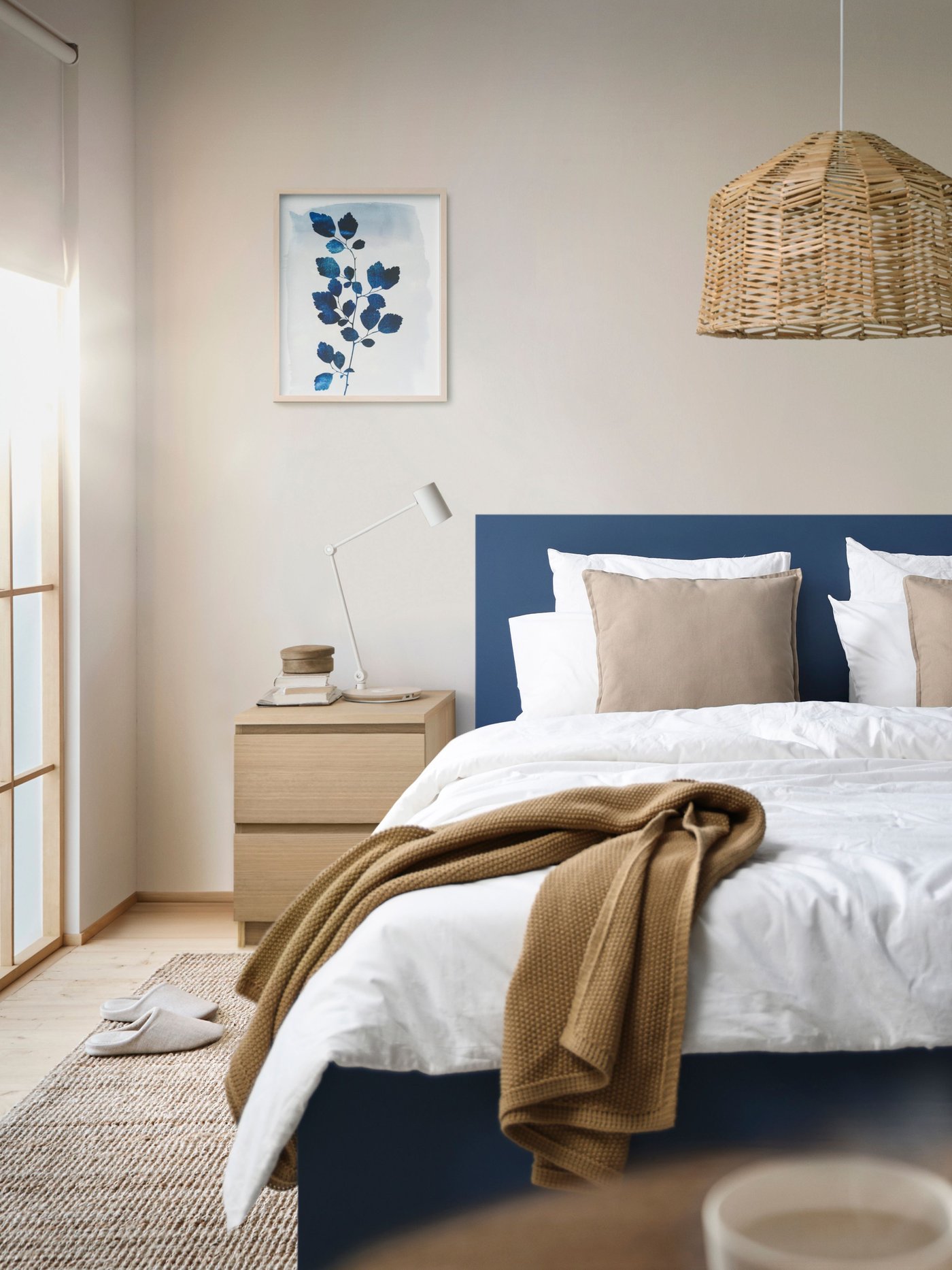 Blue MALM queen-sized bedframe in the bedroom with a chest of drawers next to the bed. 