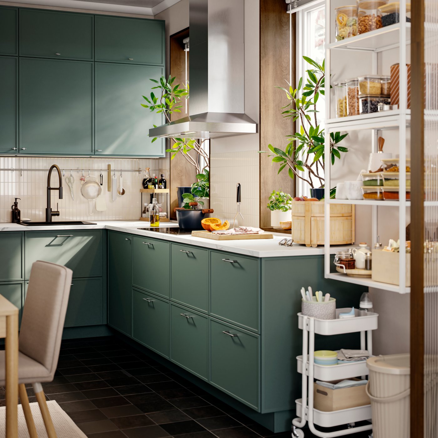 A small kitchen has several base and wall cabinets with grey-green ASPUDDEN fronts and an extractor hood next to a window.